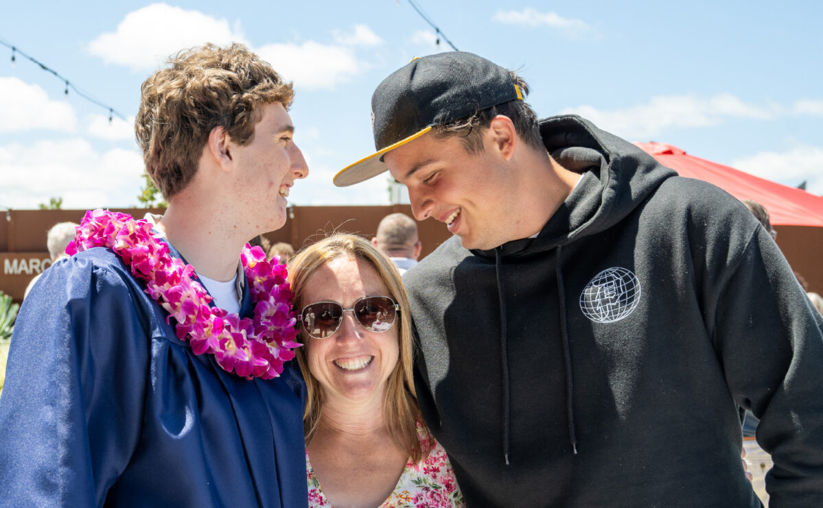 Two teens with woman smiling.