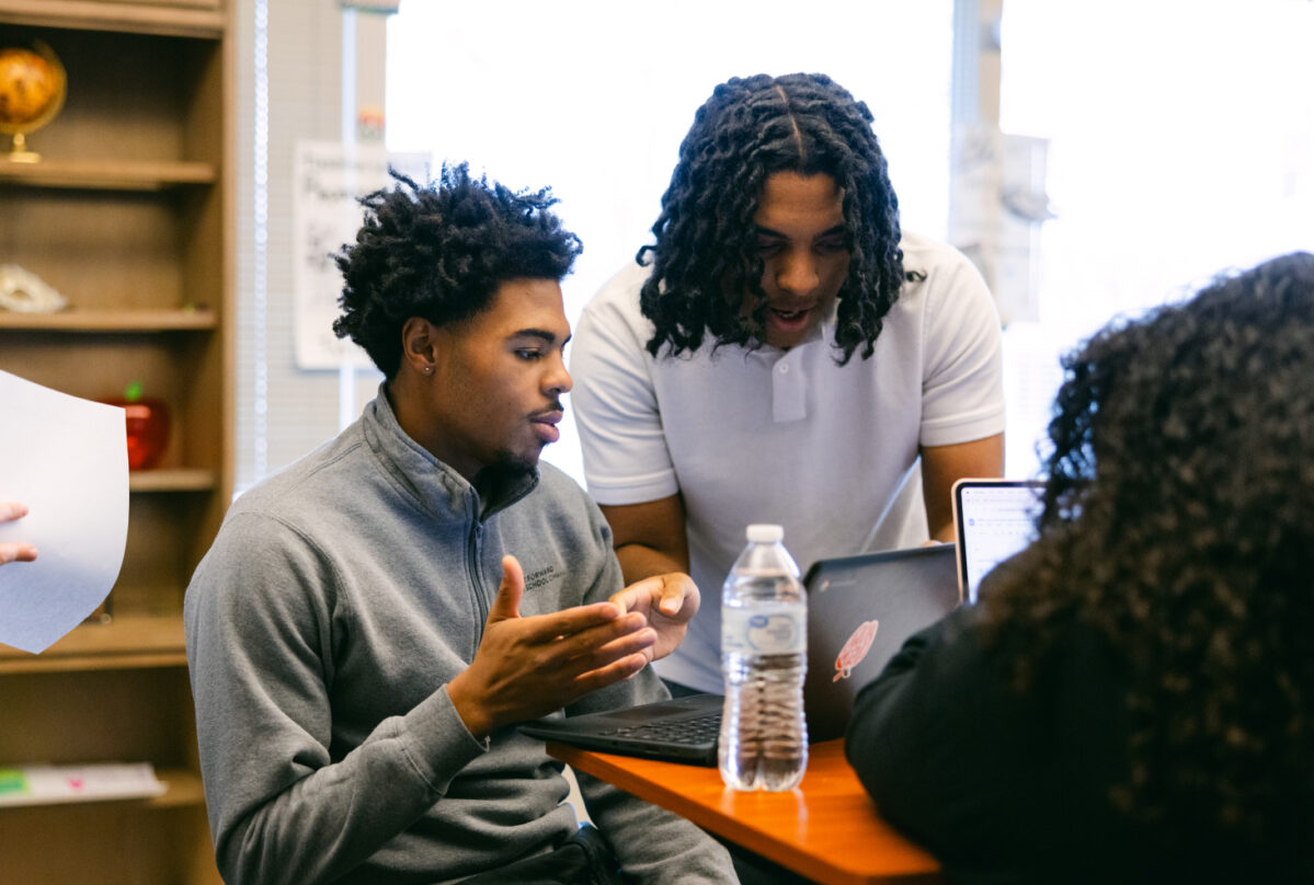 Students with laptop computers talking.