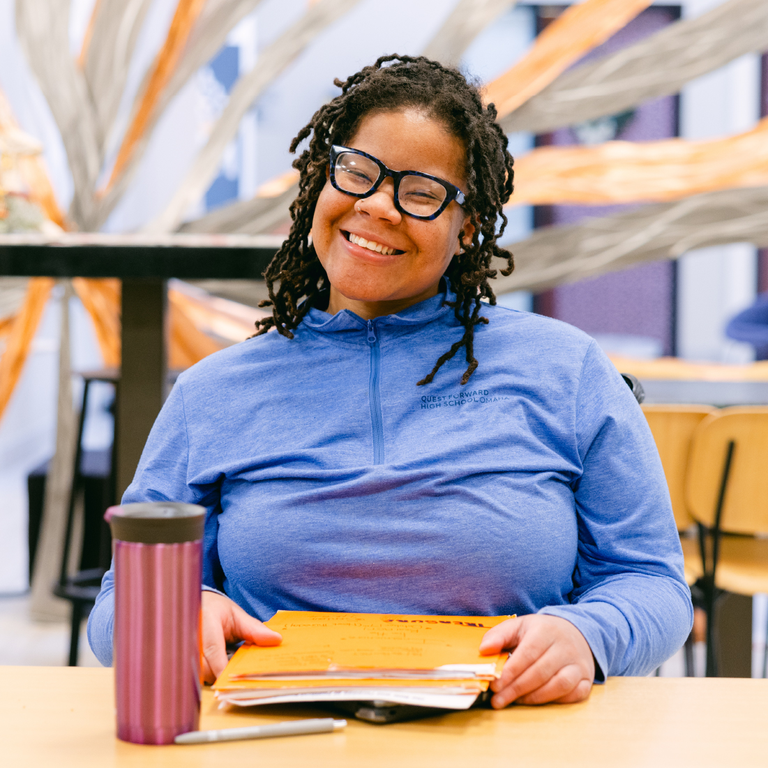 Smiling student at table.