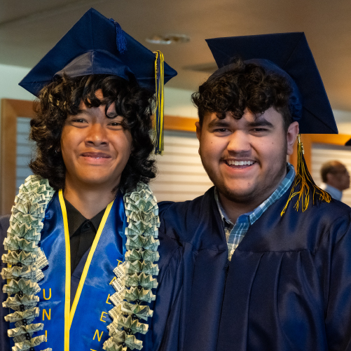 Two students in graduation caps and gowns.