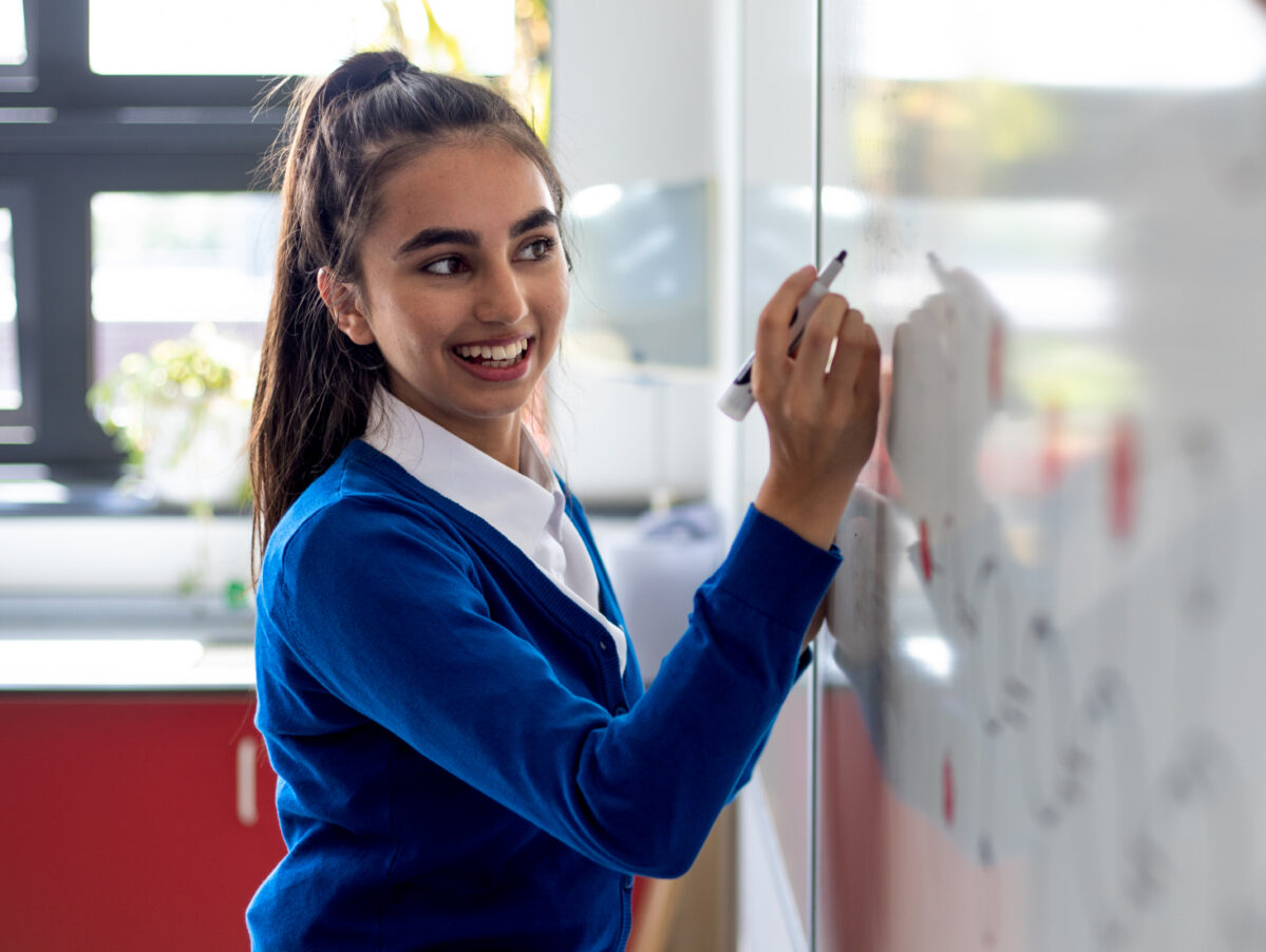 Student white boarding in classroom.