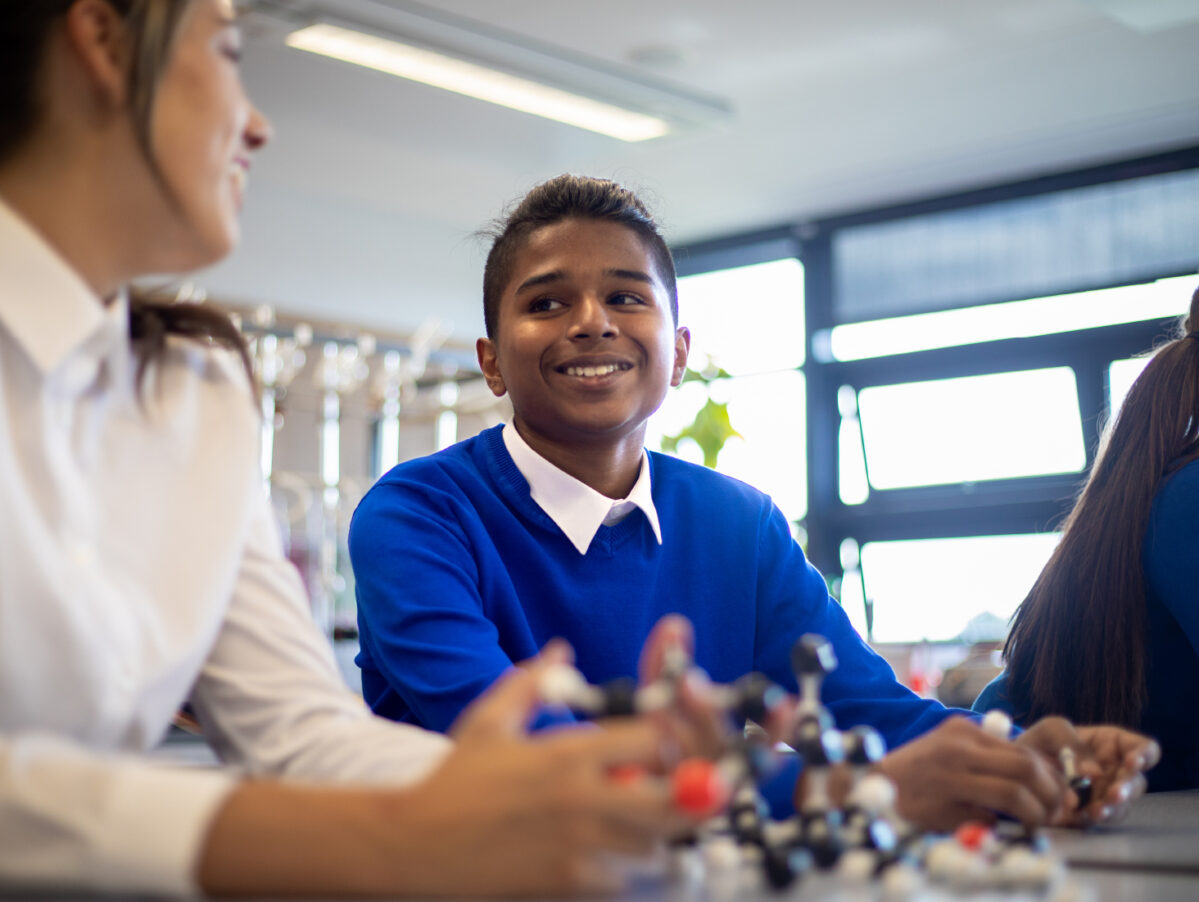 Student in science class wearing a blue uniform.
